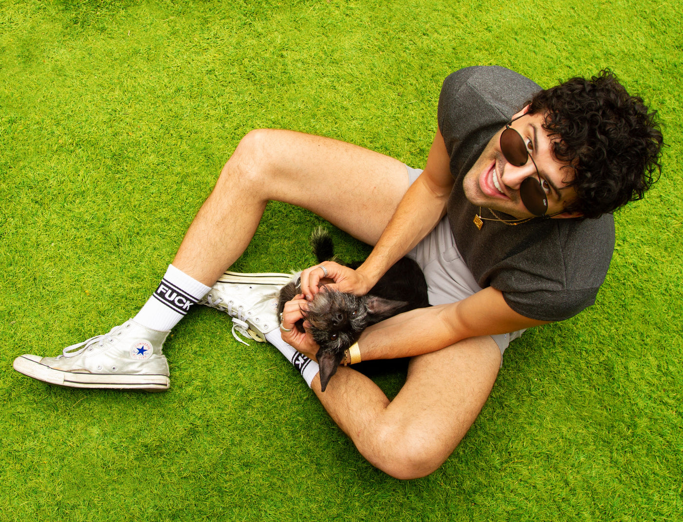 Lifestyle photo: Person wearing the socks, sitting on green grass with a dog. [lf]