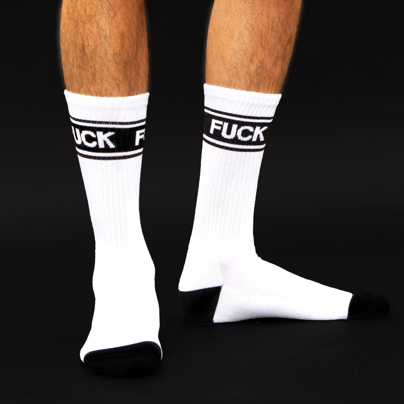 Studio shot:  Close-up of two socks, showing the 'FUCK' band and the black cuffs. [lf]