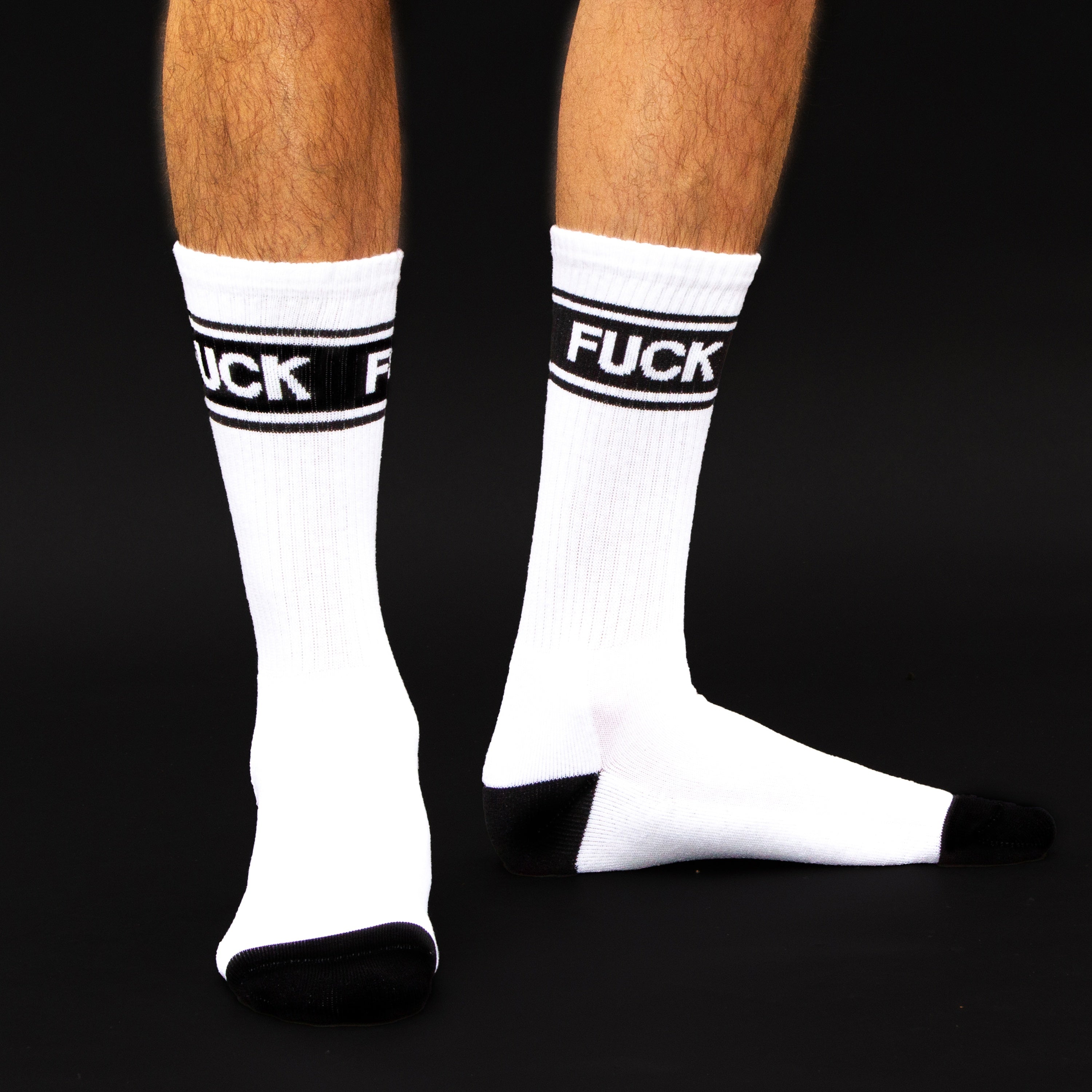 Studio shot:  Close-up of two socks, showing the 'FUCK' band and the black cuffs. [lf]