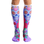 Pair of knee-high socks.  The main design features colorful sugar skulls with pink hearts and roses on a white and purple background. [lf]