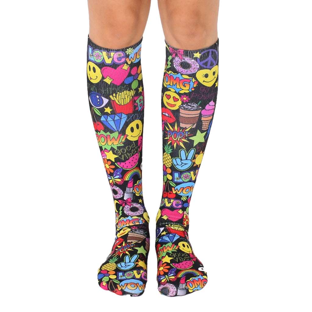 Knee-high socks in black with a colorful all-over print of smiley faces, peace signs, and other fun 90s-style graphics. [lf]