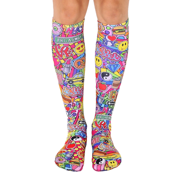 Knee-high socks in pink, yellow, and other bright colors. Features a fun, collage-style design of NYC imagery like smiley faces, pizza, and traffic lights. [lf]