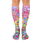 Pair of knee-high socks. Pink base with colorful cartoon designs, including unicorns, cupcakes, and peace signs. [lf]