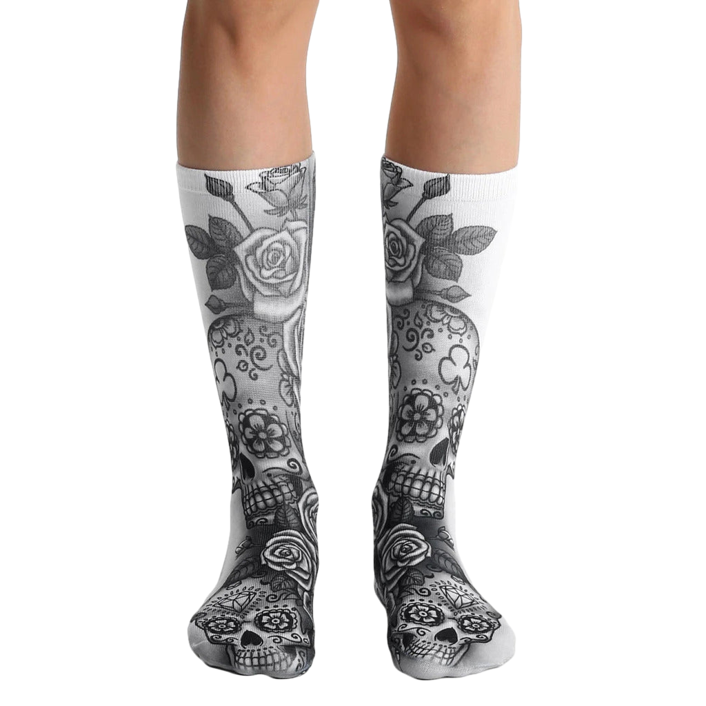 A pair of white crew socks with a gray sugar skull and rose design. The skulls have floral details. [lf]