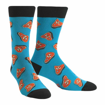 Pair of teal crew socks featuring a pattern of cartoonish orange steaks. Black cuffs and toes.