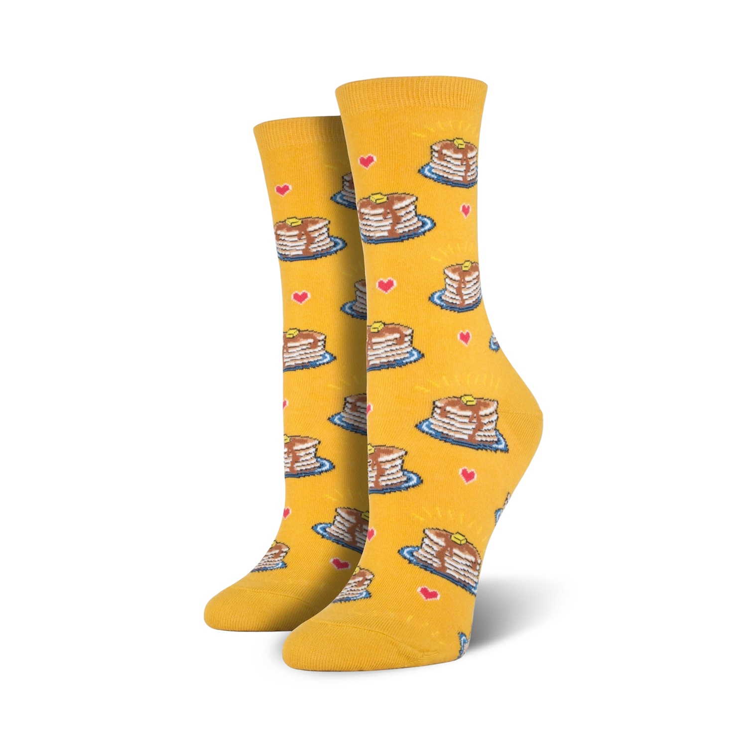 A pair of women's crew socks in mustard yellow. The socks are adorned with a pattern of illustrated pancakes, hearts, and syrup drizzles.