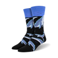 Crew socks featuring a black background with light blue and grey whales swimming. A light blue band at the top represents the ocean surface.