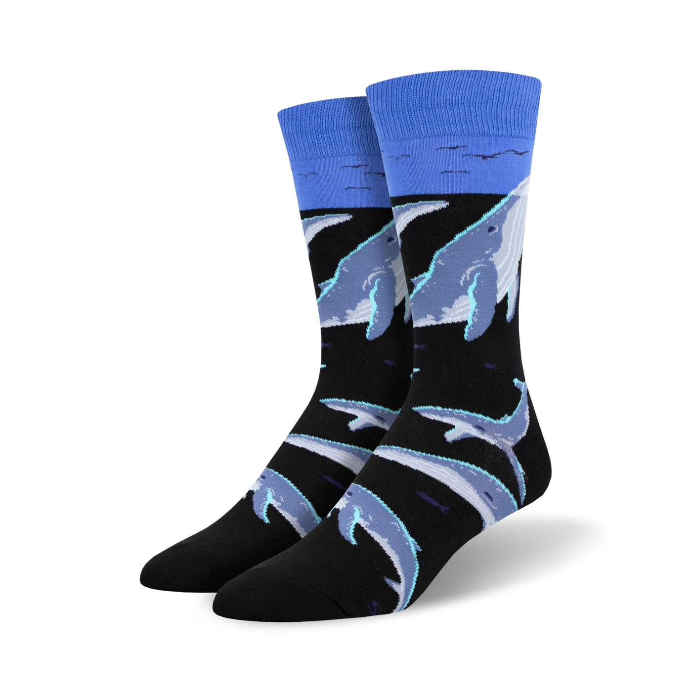 Crew socks featuring a black background with light blue and grey whales swimming. A light blue band at the top represents the ocean surface.
